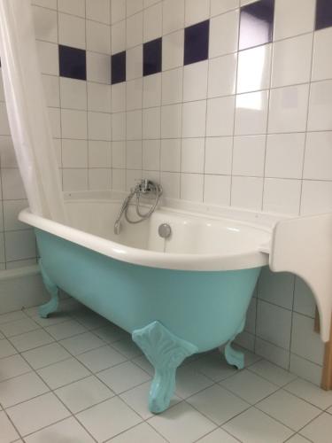 a blue bath tub in a bathroom with tiles at Hotel Richelieu in Calais