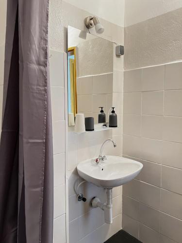 a white bathroom with a sink and a mirror at Family Majčica - villa Malo Misto in Klek