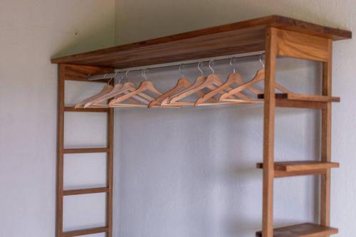 a wooden rack of hangers in a closet at Casa Queña, in the heart of Mazunte in Mazunte
