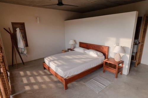 a bedroom with a bed and a nightstand and two lamps at Casa Queña, in the heart of Mazunte in Mazunte