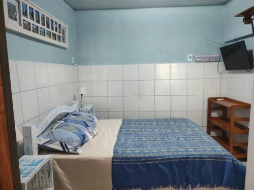 a small bedroom with a bed and a tv at Cantinho especial in Recife