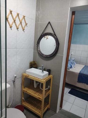 a bathroom with a sink and a mirror and a bed at Cantinho especial in Recife
