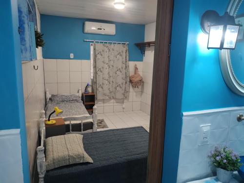 a bedroom with two beds and a blue wall at Cantinho especial in Recife