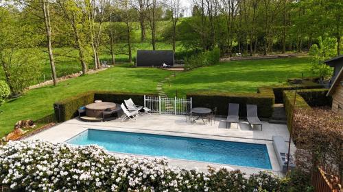 a swimming pool in a yard with a lawn at L'Arbre de Vie in Goesnes