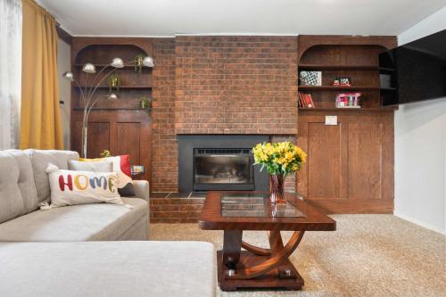a living room with a couch and a fireplace at 2BR Cozy Suite w Fireplace! FREE Banff Pass, Parking, Netflix! Near Golf Course! in Calgary