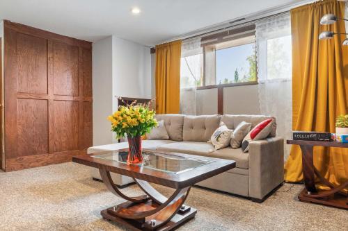 a living room with a couch and a table at 2BR Cozy Suite w Fireplace! FREE Banff Pass, Parking, Netflix! Enjoy Yoga Classes or Plan Your Golf Trip! in Calgary