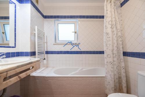 a bathroom with a tub and a sink at Casa das Casinhas by East Algarve Guest in Tavira