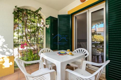 a white table and white chairs on a patio at Casa das Casinhas by East Algarve Guest in Tavira