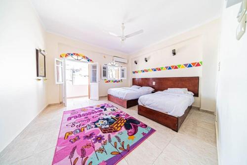a bedroom with two beds and a purple rug at Bob Marley Guest House in Aswan