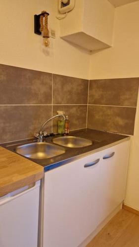 une cuisine avec un évier et un plan de travail dans l'établissement Maison de bourg Clermont-Ferrand, à Montferrand