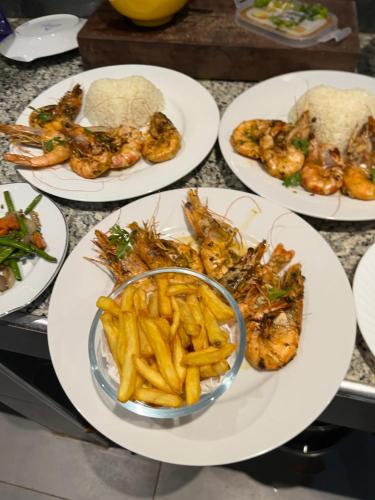 a group of plates of food with shrimp and french fries at Villa Chez Diarra in Saint-Louis