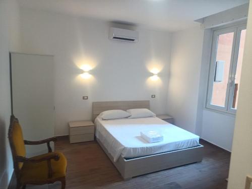 a bedroom with a bed and a chair and a window at Camera Appartamento Terminal Traghetti in Genova