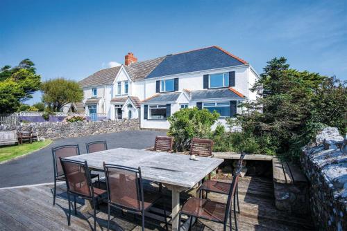 a table and chairs in front of a house at Channel View – 3 Bedroom House - Rhossili Bay in Oxwich