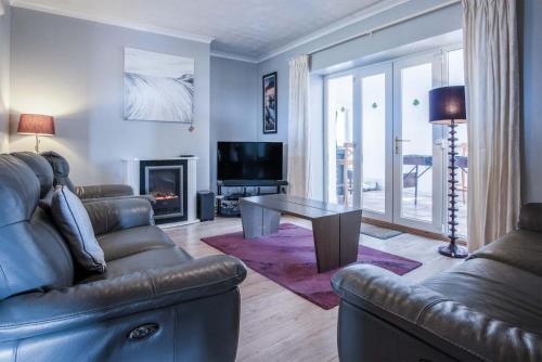 a living room with a couch and a table at Channel View – 3 Bedroom House - Rhossili Bay in Oxwich