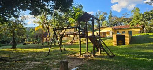 a swing set in a park with a house at Hospedagem Fazenda Nova América in Brotas