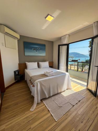 a bedroom with a large bed and a large window at Pousada do Canto in Abraão