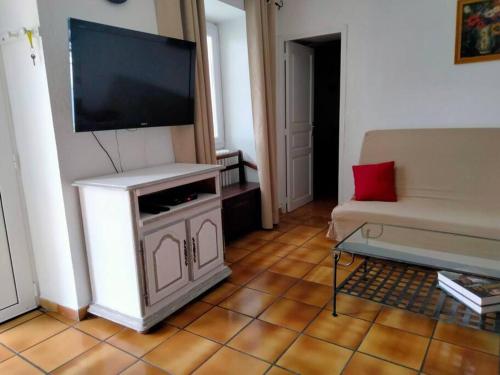 un salon avec une télévision à écran plat et un canapé dans l'établissement Maison de village corse, à Campitello