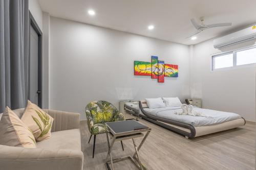 una sala de estar con dos camas y un sofá en 芭提雅21航站楼附近8卧9卫轻奢现代别墅带独立歌房, en Norte de Pattaya