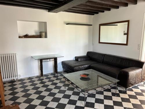 ein Wohnzimmer mit Sofa und Tisch in der Unterkunft Maison de campagne familiale in LʼHabit