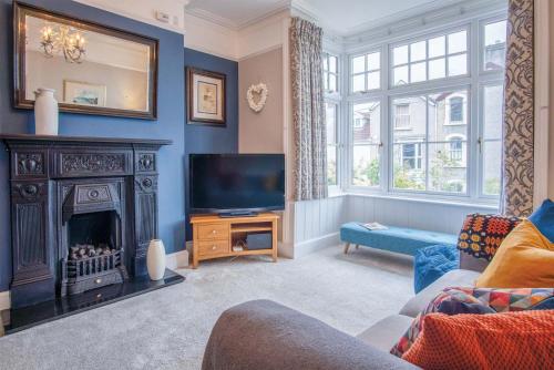 a living room with a fireplace and a television at Overland Road – 4 Bedroom House – Mumbles in The Mumbles