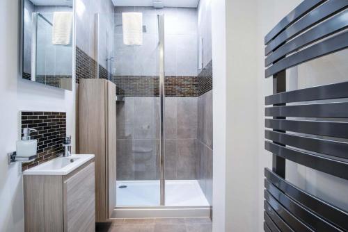 a bathroom with a shower and a sink and a tub at Overland Road – 4 Bedroom House – Mumbles in The Mumbles