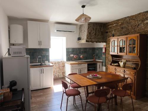 a kitchen with a table and chairs and a refrigerator at Casa da Courela do Olival - Santo Aleixo