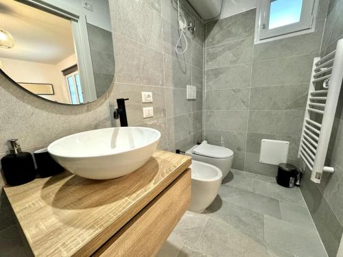 a bathroom with a sink and a toilet and a mirror at Casa Svalto Mono in Udine