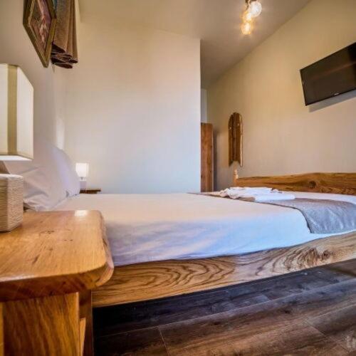 a bedroom with a wooden bed with a wooden table at La Maisonnette in Braşov