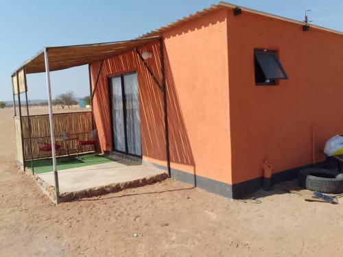 een klein huis midden in de woestijn bij Petrified forest restcamp in Khorixas
