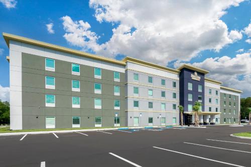 a large office building with a parking lot at HomeTowne Studios by Red Roof Tampa - Airport in Tampa