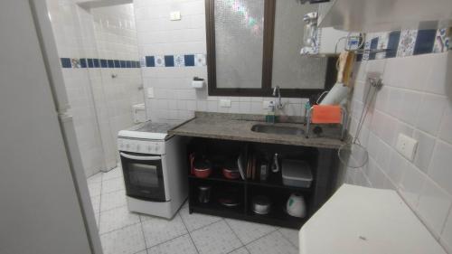 a small kitchen with a sink and a stove at Apartamento Largo dos Coqueiros in Riviera de São Lourenço