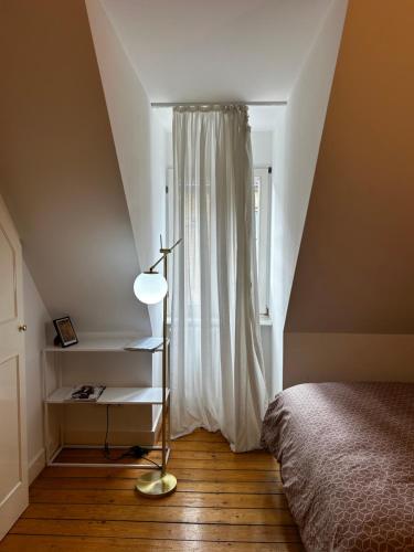 une chambre avec un lit, une lampe et une fenêtre dans l'établissement MA Zentrum Stadthaus Zimmer 6, à Mannheim