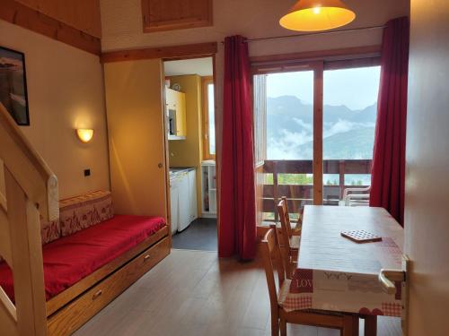 un salon avec une table et une salle à manger dans l'établissement Appartement cosy près des pistes avec balcon et TV - FR-1-181-2832, à La Plagne Tarentaise