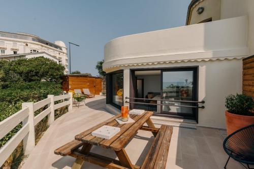 - une table en bois sur le balcon d'une maison dans l'établissement Phare Ouest - Biarritz, à Biarritz