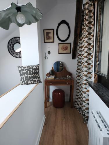 un couloir avec une table, une lampe et une chaise dans l'établissement Sous les toits de Triboulet, à Blois