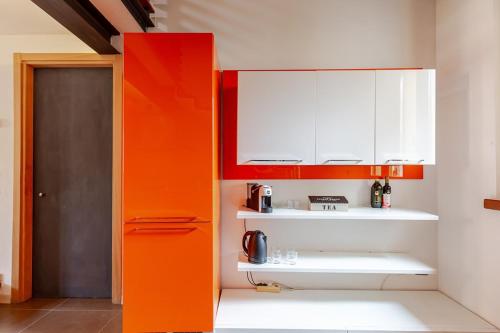 a kitchen with orange and white cabinets at Piacenza Open Space in Piacenza