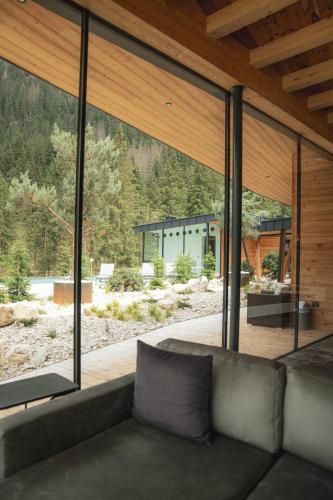 a living room with a couch and large windows at Hotel Majon Miramonti in Canazei