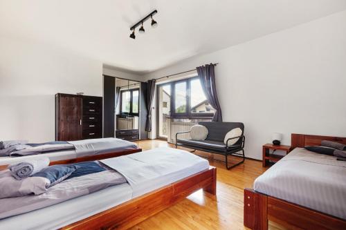 a bedroom with two beds and a chair at Dom Kubicowka in Rybarzowice