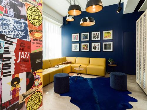 a living room with a yellow couch and blue walls at Holiday Inn - the niu, Dairy Haarlem in Haarlem