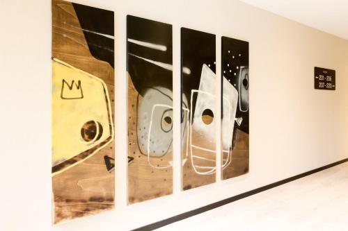 a row of paintings on a wall in an art gallery at Holiday Inn - the niu, Dairy Haarlem in Haarlem