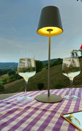two glasses of wine on a table with a lamp at La Lavandula in Poppi