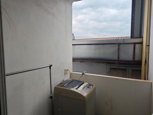 Un baño con ventana y un bote de basura en una habitación. en Gold house apartment 2, en Vientiane
