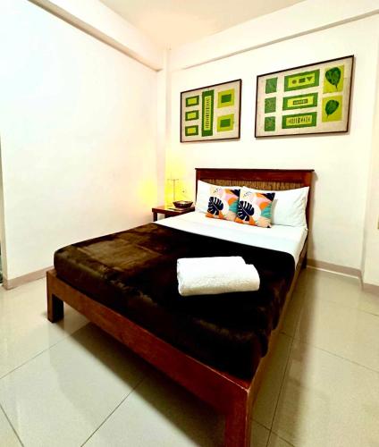 a bedroom with a large bed with two pillows at Papierus Pensionne in Kalibo