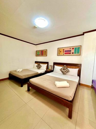 a bedroom with two beds in a room at Papierus Pensionne in Kalibo