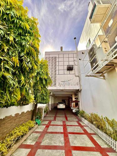 a walkway leading to a building with a parking garage at Papierus Pensionne in Kalibo