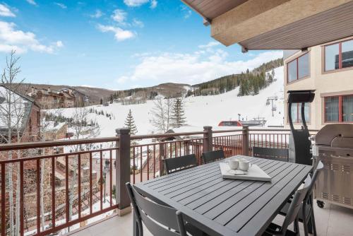 a table on a balcony with a view of a ski slope at One Beaver Creek 54 by East West Hospitality in Avon