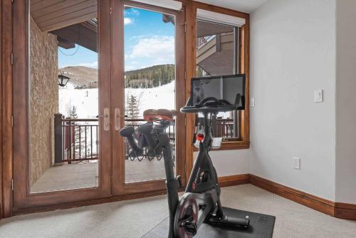 a room with a exercise bike in front of a window at One Beaver Creek 54 by East West Hospitality in Avon