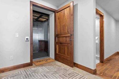 an empty hallway with a wooden door in a room at One Beaver Creek 54 by East West Hospitality in Avon