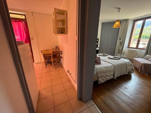 a bedroom with a bed and a table in a room at Apartment La Viarhôna à Brégnier-Cordon in Brégnier-Cordon