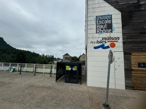 a sign on the side of a building with a pay phone at Apartment La Viarhôna à Brégnier-Cordon in Brégnier-Cordon